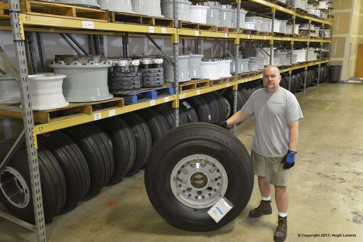 An employee next to an airplane tire